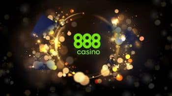 888 casino logo encircled by golden bookeh light alongside black playing cards and dices on a black background with fading sparkles