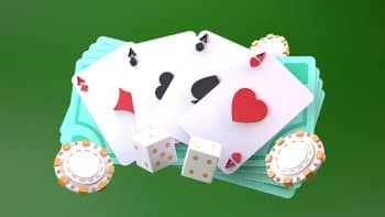 Poker chips and cards surrounding a stack of money on a dark green background