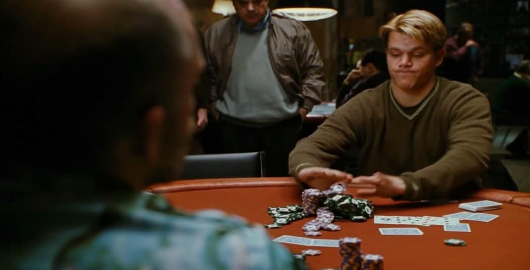 Rounders casino movie scene with the main character sitting at a poker table pushing piles of chips towards the dealer
